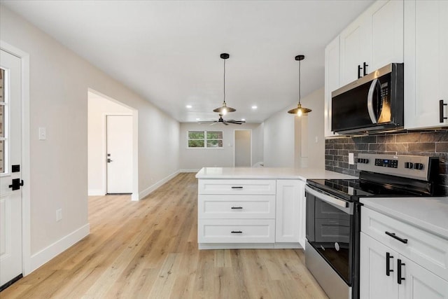 2506 Swan Ct, Houston, TX 77058 - kitchen with stainless steel appliances, a peninsula, light wood finished floors, white cabinets, and recessed lighting