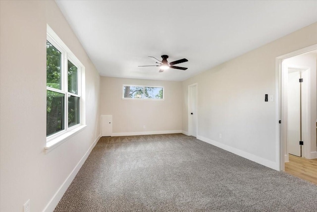 spare room with light carpet, ceiling fan, and baseboards