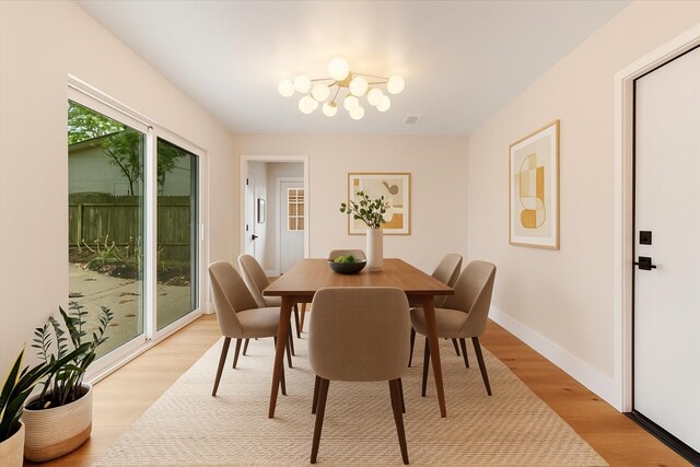 2506 Swan Ct, Houston, TX 77058 - dining area featuring light wood-type flooring, a chandelier, and baseboards