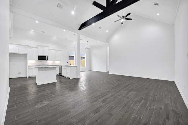 201 Big Spring Dr, Anahuac, TX 77514 - unfurnished living room featuring dark wood-style floors, beam ceiling, baseboards, a ceiling fan, and a sink
