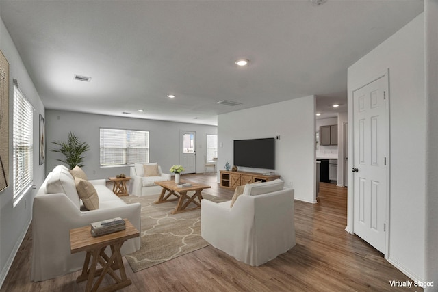 living area featuring wood finished floors, recessed lighting, and baseboards