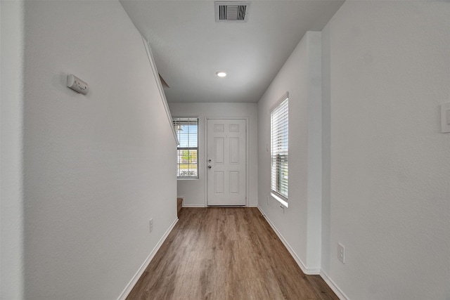 doorway featuring baseboards, recessed lighting, visible vents, and wood finished floors