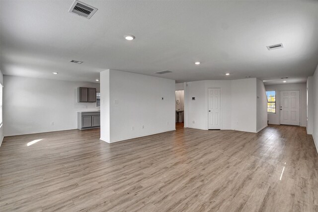 unfurnished living room with light wood-type flooring, visible vents, and recessed lighting