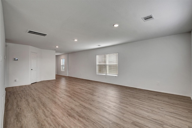 empty room with wood finished floors, recessed lighting, and baseboards