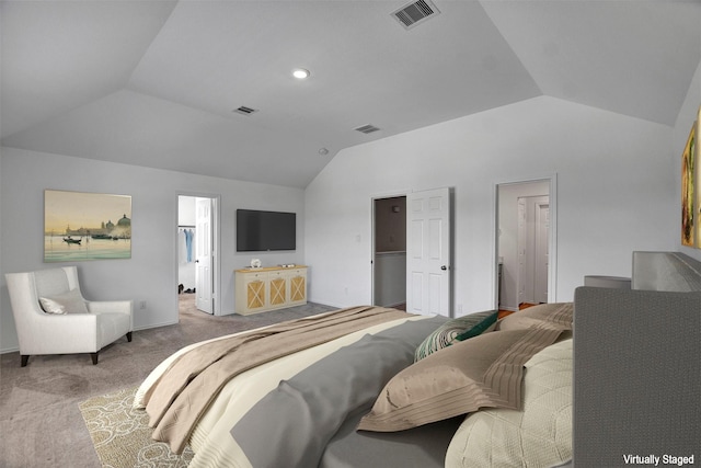 carpeted bedroom featuring lofted ceiling, visible vents, and a walk in closet