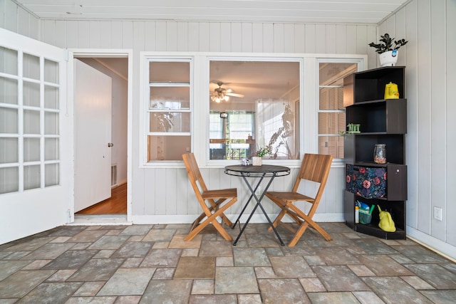 815 Iwo St, Alvin, TX 77511 - dining space featuring stone finish floors, ceiling fan, and wood walls