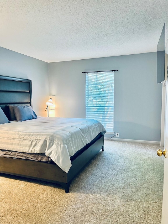 bedroom with carpet flooring, a textured ceiling, and baseboards