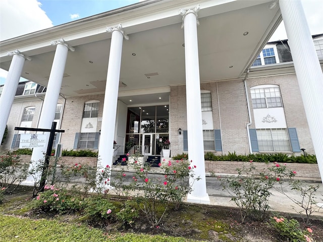 view of exterior entry featuring brick siding