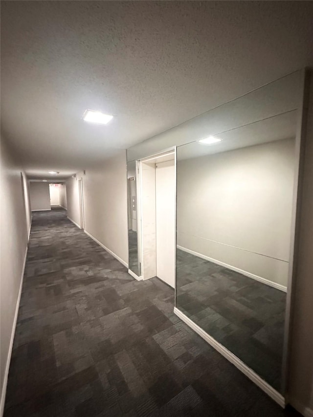 corridor with dark carpet and baseboards