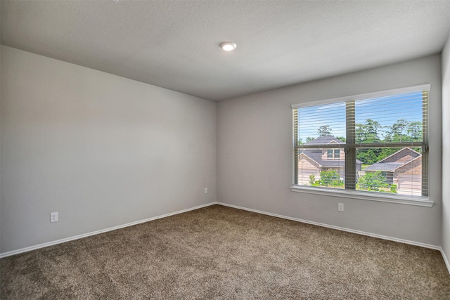 carpeted empty room featuring baseboards and a textured ceiling