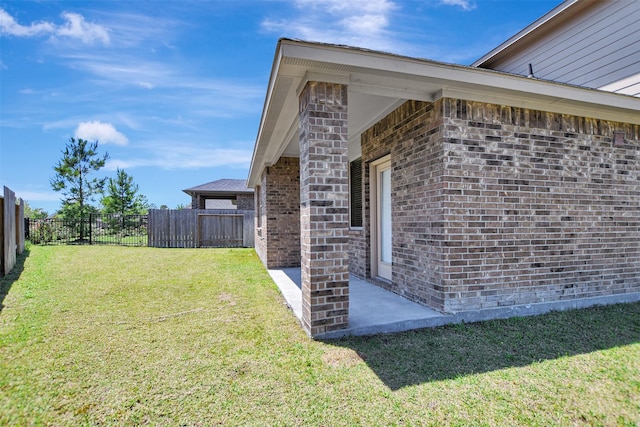 view of side of property featuring brick siding and a patio