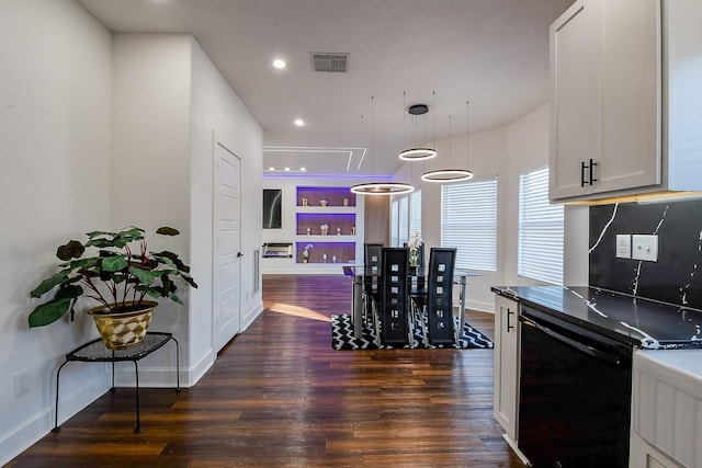kitchen with dark wood finished floors, dishwasher, baseboards, and recessed lighting