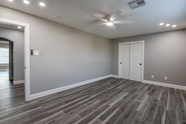 unfurnished bedroom featuring dark wood-style flooring, baseboards, recessed lighting, and a closet