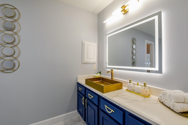 bathroom with marble look tiles, baseboards, and vanity
