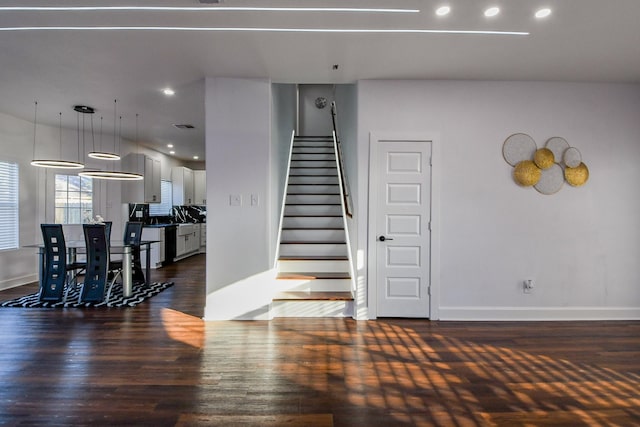stairs featuring wood finished floors, baseboards, and recessed lighting