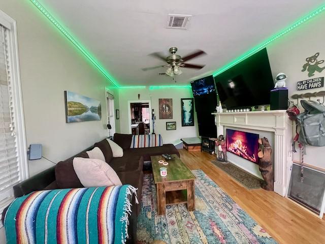 1227 W 25th St, Houston, TX 77008 - living room with wood finished floors, a fireplace with flush hearth, and ceiling fan