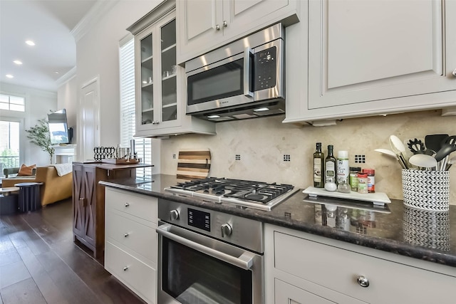9450 London Bridge Sta, Houston, TX 77045 - kitchen with stainless steel appliances, crown molding, dark wood-style floors, glass insert cabinets, and backsplash