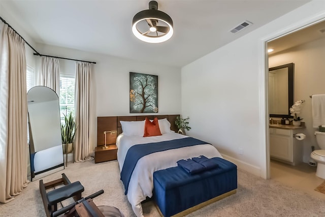 9450 London Bridge Sta, Houston, TX 77045 - bedroom featuring light carpet, ensuite bathroom, and baseboards