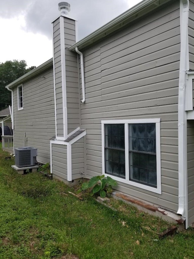 1305 Saint Lawrence River Rd, Conroe, TX 77316 - view of property exterior featuring central AC, a chimney, and a yard