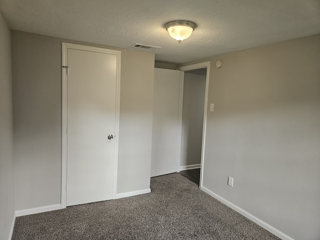 1305 Saint Lawrence River Rd, Conroe, TX 77316 - unfurnished bedroom with a textured ceiling, dark carpet, baseboards, and a closet