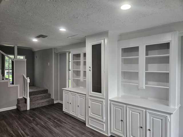 1305 Saint Lawrence River Rd, Conroe, TX 77316 - bar with dark wood-style flooring, a textured ceiling, baseboards, and stairs