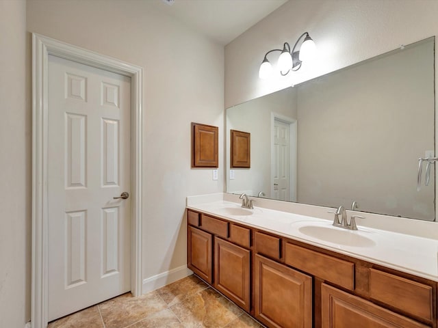 bathroom featuring double vanity, tile patterned floors, and baseboards