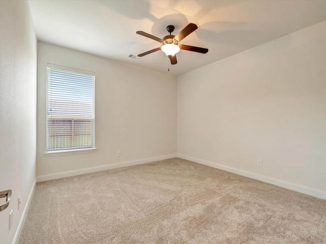 spare room with carpet floors, a ceiling fan, and baseboards