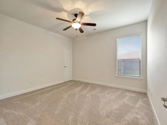 empty room with light carpet, ceiling fan, and baseboards