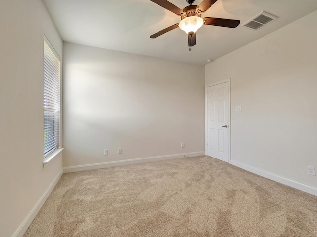 spare room with carpet, ceiling fan, and baseboards