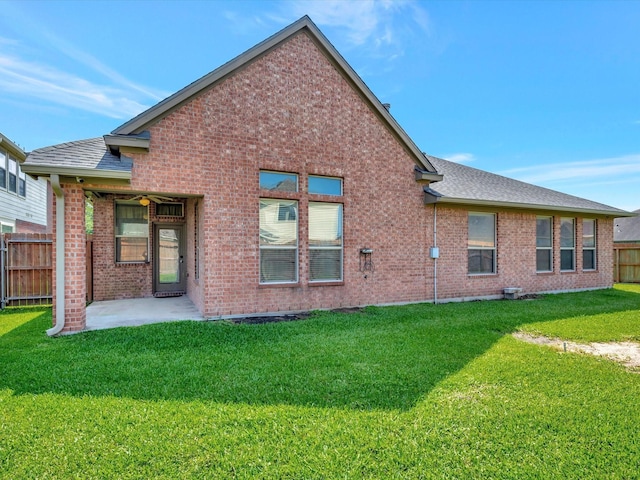rear view of property with brick siding, a patio, and a shingled roof
