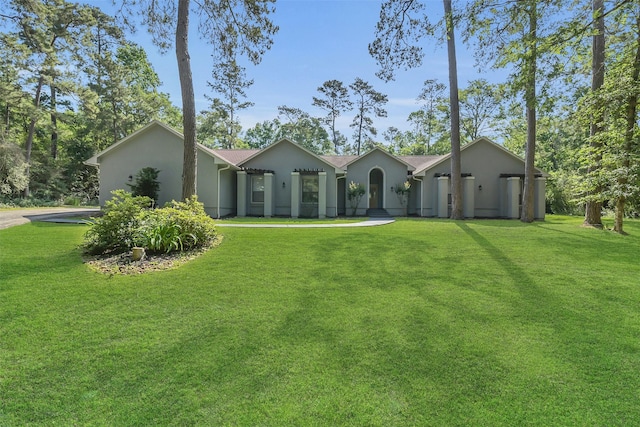 single story home featuring stucco siding and a front yard