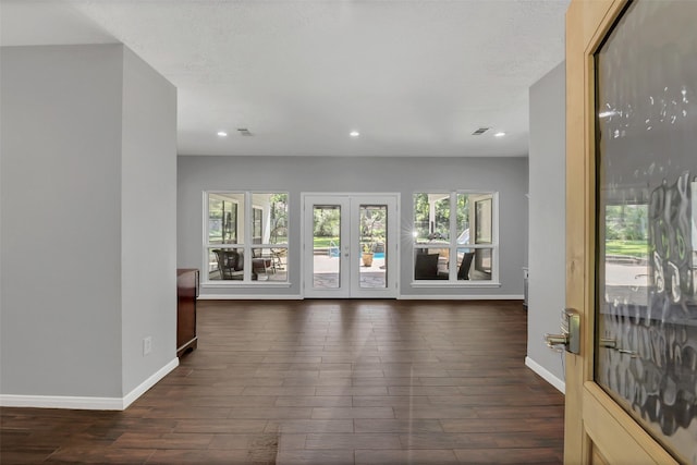 unfurnished living room with plenty of natural light, baseboards, dark wood-type flooring, and recessed lighting