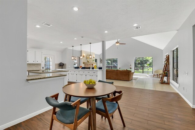 dining area with wood finished floors, a ceiling fan, recessed lighting, vaulted ceiling, and baseboards