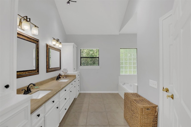 bathroom with lofted ceiling, double vanity, tile patterned flooring, a bath, and baseboards