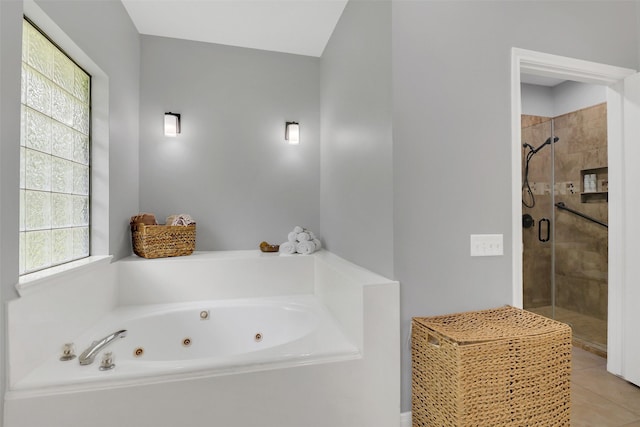 bathroom featuring a shower stall, a tub with jets, and tile patterned flooring