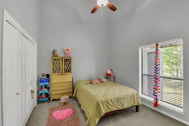 carpeted bedroom with a closet, baseboards, and ceiling fan