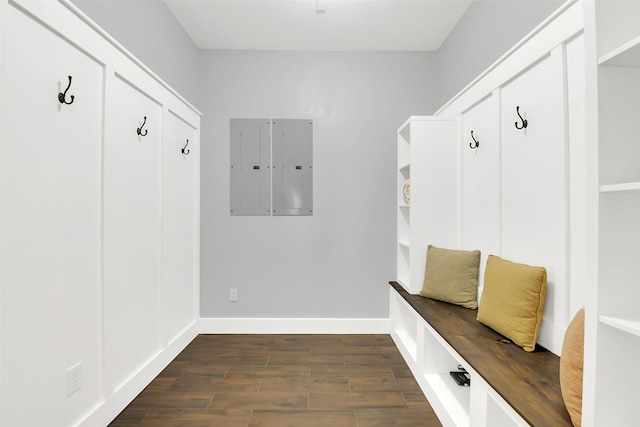 mudroom featuring dark wood-type flooring, baseboards, and electric panel