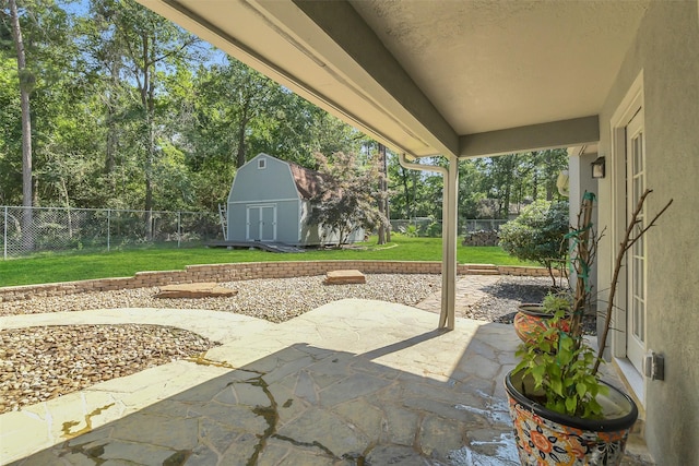view of patio featuring a shed, an outdoor structure, and view of wooded area