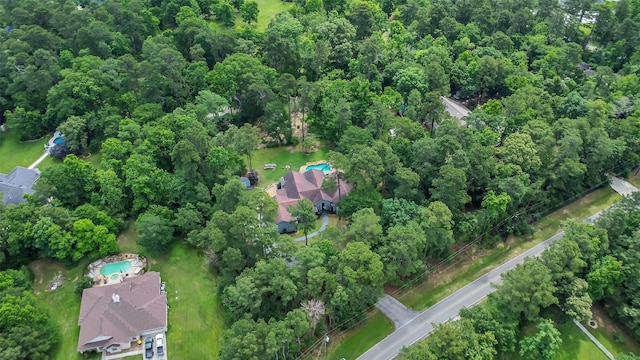 aerial view of property and surrounding area with a heavily wooded area