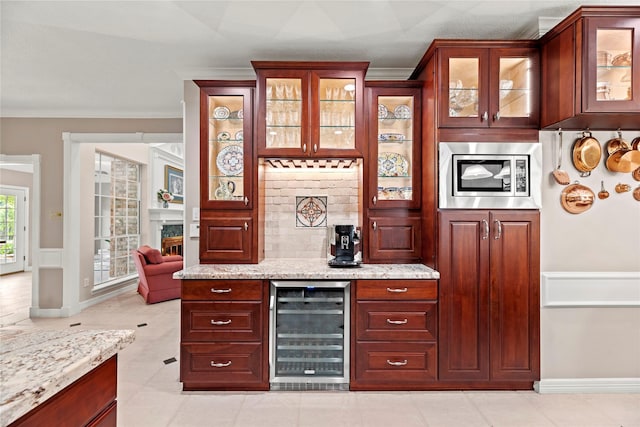 19827 Timberwind Ln, Houston, TX 77094 - indoor dry bar featuring beverage cooler, stainless steel microwave, wainscoting, ornamental molding, and a fireplace