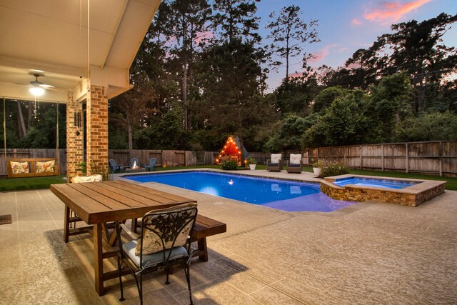 514 Chirping Sparrow Ct, Pinehurst, TX 77362 - pool at dusk with a fenced backyard, a patio area, a pool with connected hot tub, and outdoor dining area