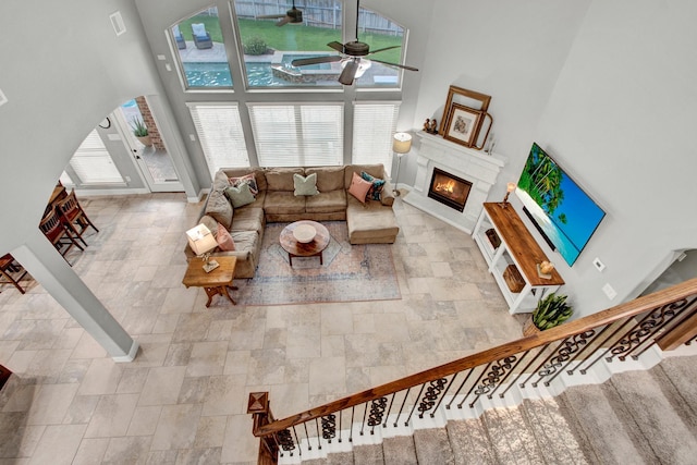 514 Chirping Sparrow Ct, Pinehurst, TX 77362 - living room featuring a high ceiling, healthy amount of natural light, ceiling fan, and stone tile floors