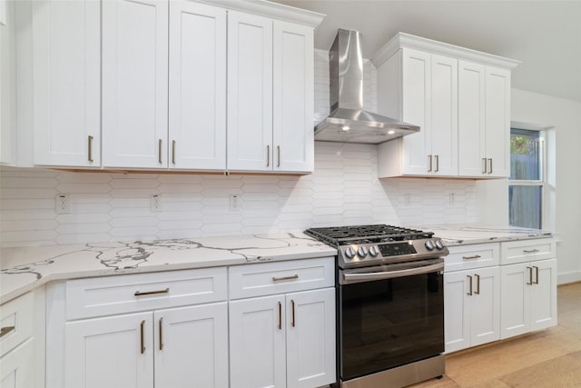 317 Kelley St, Houston, TX 77009 - kitchen featuring stainless steel gas range, wall chimney range hood, white cabinets, and backsplash