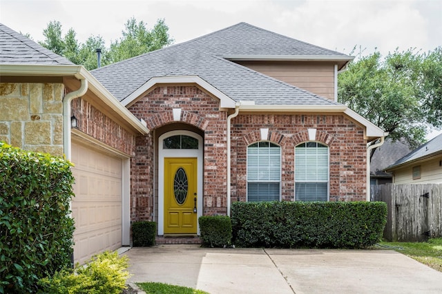 21623 Balsam Brook Ln, Katy, TX 77450 - property entrance with a shingled roof, brick siding, an attached garage, fence, and concrete driveway