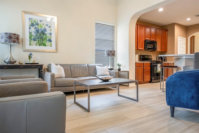 21623 Balsam Brook Ln, Katy, TX 77450 - living area with arched walkways, light wood-style flooring, and recessed lighting