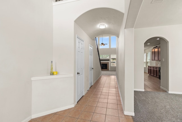 30722 Lavender Trace Dr, Spring, TX 77386 - hall featuring arched walkways, light tile patterned floors, baseboards, and lofted ceiling