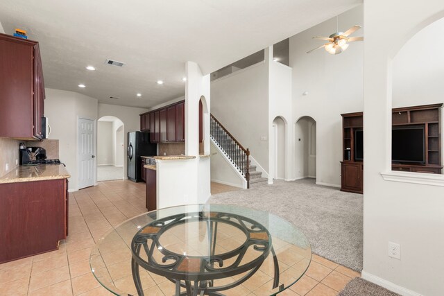 30722 Lavender Trace Dr, Spring, TX 77386 - kitchen featuring arched walkways, light tile patterned flooring, ceiling fan, freestanding refrigerator, and backsplash
