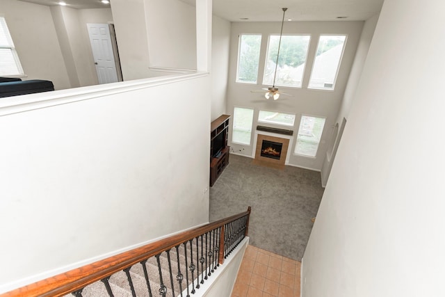30722 Lavender Trace Dr, Spring, TX 77386 - staircase featuring a ceiling fan, a tiled fireplace, carpet floors, and tile patterned floors