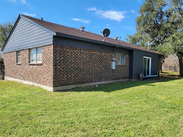 view of side of property with a lawn and brick siding