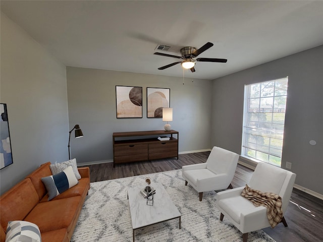 living area with wood finished floors, baseboards, and a ceiling fan